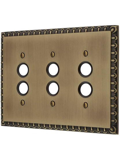 Ovolo Triple Gang Push-Button Switch Plate in Antique Brass.